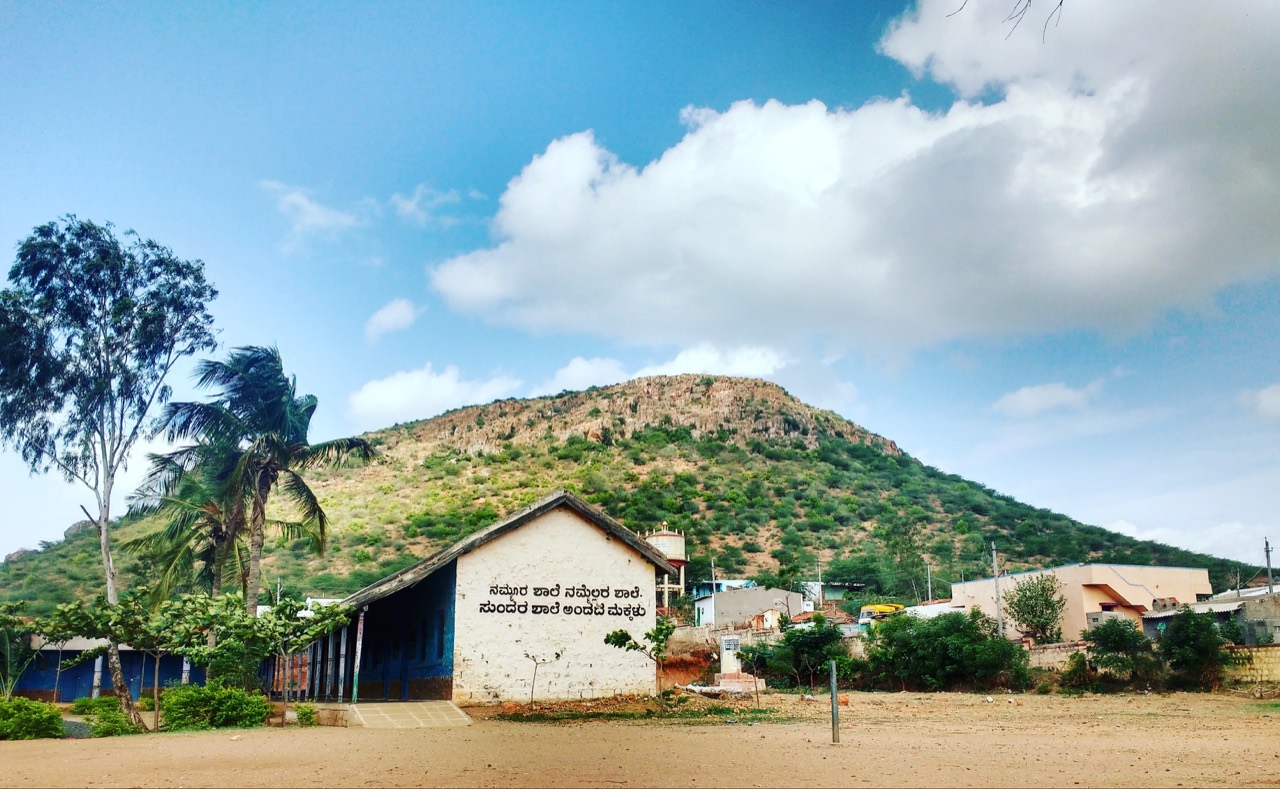 ಶಾಲೆಯ ಕಟ್ಟಡ ಮತ್ತು ಅದರ ಹಿಂದಿರುವ ಗುಡ್ಡದ ನೋಟ
